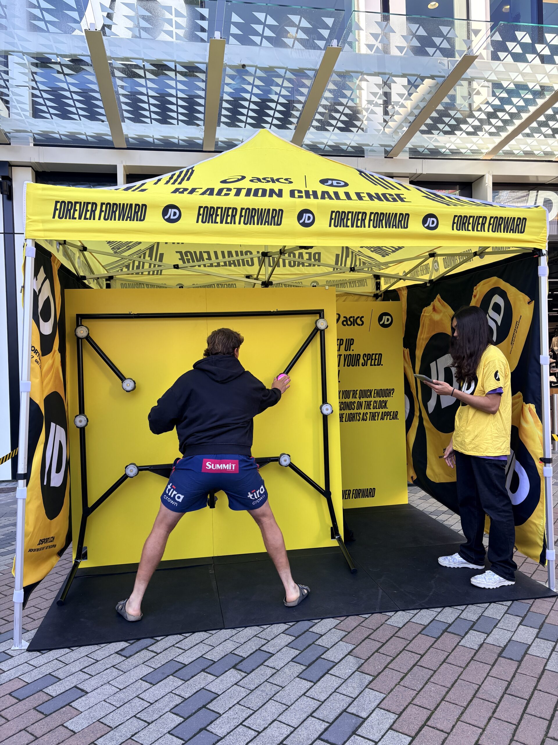 man playing reaction timer wall challenge in yellow tent